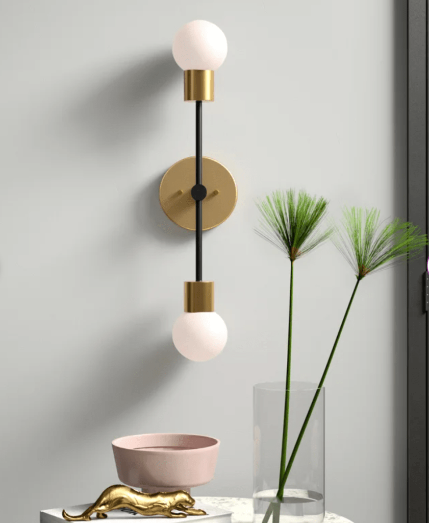 mid mod wall sconce circle with one bulb on either end of a vertical rod in brass and black. 